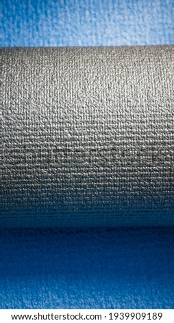 Rolled black mat on blue mat