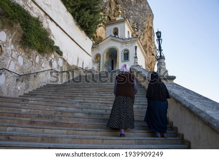 orthodox church in the mountain. Two nuns climb the stone stairs to the orthodox church located in the mountain. Copy space. Church background.