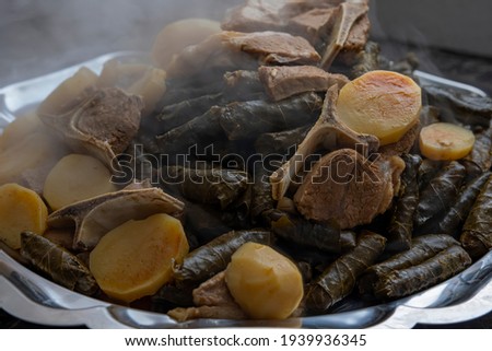 Hot just finished cooked Plate of stuffed grape leaves called Dolma , made from vines with rice, meat and spices.