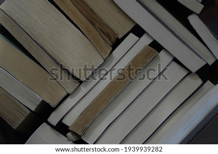 Books arranged horizontally and vertically. Old and new book pages.