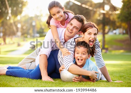 Family Lying On Grass In Park Together Royalty-Free Stock Photo #193994486