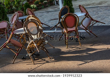 An empty summer outdoor area of a restaurant or cafe in a historic downtown is closed during lockdown. Tables and chairs without visitors. Challenging times business in HoReCa during a pandemic.