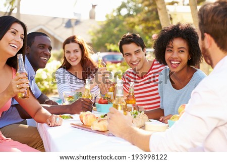 Group Of Friends Enjoying Meal At Outdoor Party In Back Yard Royalty-Free Stock Photo #193998122