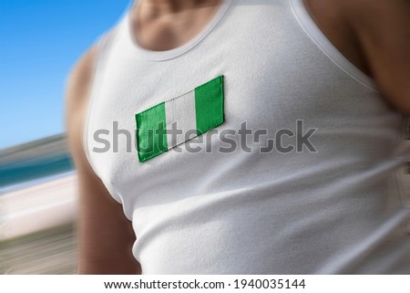 The national flag of Nigeria on the athlete's chest.