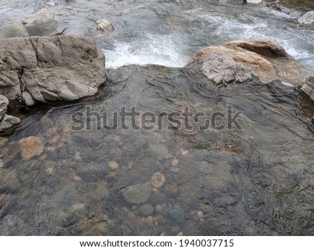 A river filled with rocks that drain water directly from a spring in Bogor or known as Curug Leuwi Hejo Bogor, Indonesia.