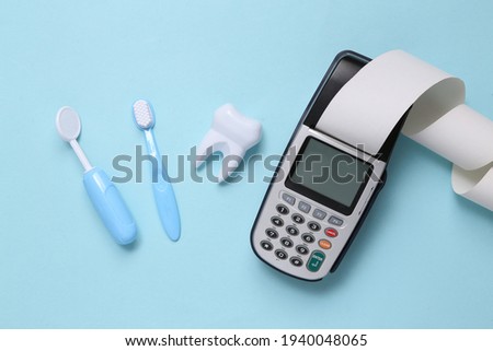 Toy dentist tools, payment terminal on a blue background. Dental care