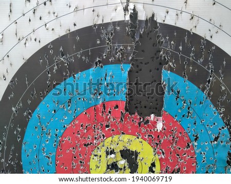 Archery target close up with many arrow holes in Gold, red, blue and black  Royalty-Free Stock Photo #1940069719