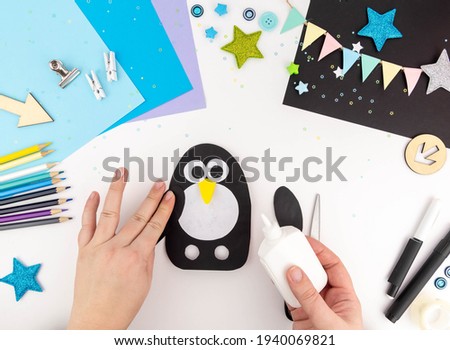 Step-by-step instruction of making a penguin out of paper with children.