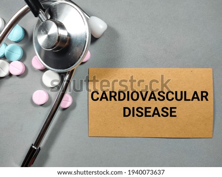 Selective focus.Word CARDIOVASCULAR DISEASE with stethoscope on gray background.Medical concept.