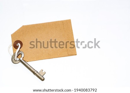 Key and brown paper tag on white background