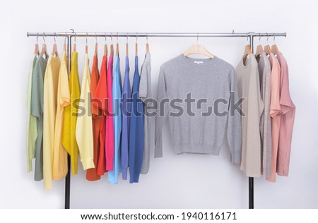 collection of colorful row t-shirts,sweater hanging on hangers