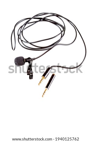 Small lavalier microphone or lapel mic with clip and adapter for computer on white background. Professional sound recording equipment for cell phone.