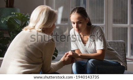 Supportive older Caucasian mom hold hands comfort caress talk with millennial female child feeling unhappy sad. Loving senior mother show support and care to upset depressed adult grownup daughter. Royalty-Free Stock Photo #1940143735