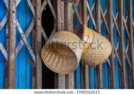 Bamboo Container hanging on rusted rolling deep blue steel doors.