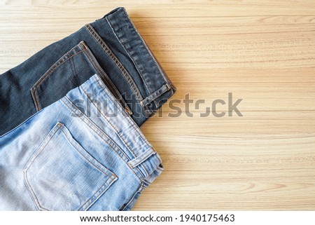 Top view of old Faded blue and dark blue jeans on wooden background with copy space