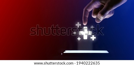 Man finger clicks on the open plus icon.Plus symbol for your web site design, logo, app, UI. Which is a virtual projection from a mobile phone. Neon , red blue lights. Royalty-Free Stock Photo #1940222635