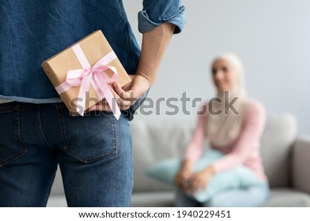 Gift box in unrecognizable man hand over waiting woman