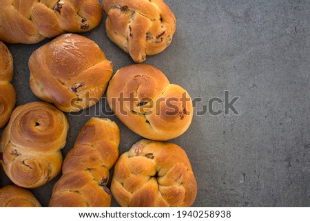 A lot of homemade buns on a table. Gray textured background with copy space. Top view photo of freshly baked buns.