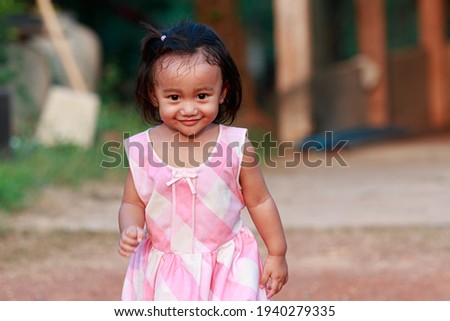 Portrait of asian baby girl, Face looking glancing with a smile,Running in the front yard