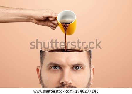 The man's head is open and coffee is poured into it from a cup. Creative background, coffee lover, brain drug, caffeine Royalty-Free Stock Photo #1940297143