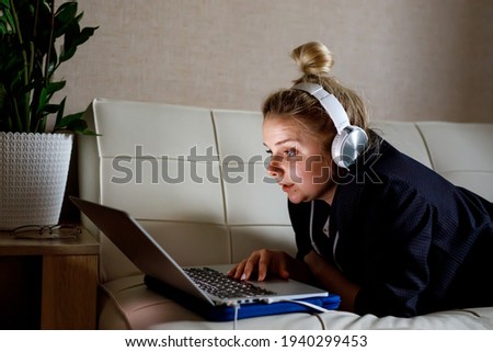 Young woman working on laptop computer while sitting at the living room