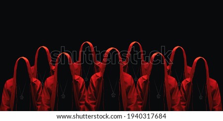 Group of mystery people in a red hooded cloaks. Isolated on black. Unrecognizable person. Hiding face in shadow. Ghostly figure. Sectarians. Conspiracy concept. Royalty-Free Stock Photo #1940317684