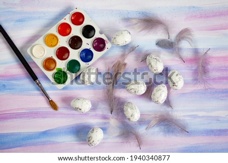 Beautiful Easter picture with watercolor, eggs and feathers with space for text.
