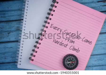 Selective focus image of magnetic compass and note book with Every Success Come From Hardest Climb quote on a wooden background with vintage effect. Motivational concept.