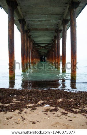 View under the dock at the beach. Coming and foamy waves under the dock	