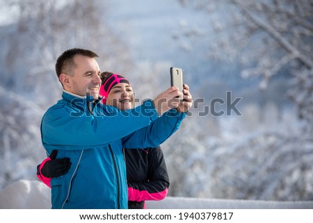 Young woman and cheerful man on christmas holidays, ejoying snow