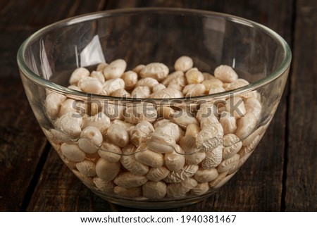 White beans in a clear vase in water ready for cooking. Close-up.