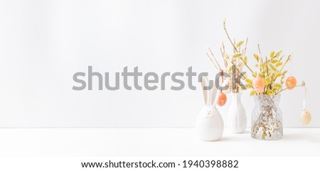 Home interior with easter decor. Willow branches in a vase, easter eggs on a light background
