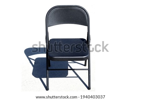 Metal Folding Chair. A classic black metal folding chair. Folding chairs are used for all types of events and gatherings. They fold closed for easy storage and transportation.  Royalty-Free Stock Photo #1940403037