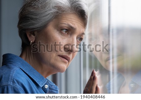 Solitude hurts so much. Cropped shot of lonely older hispanic lady lean head to window glass look at distance feel abandoned grief suffer alone. Depressed elderly woman widow mourning for gone husband Royalty-Free Stock Photo #1940408446