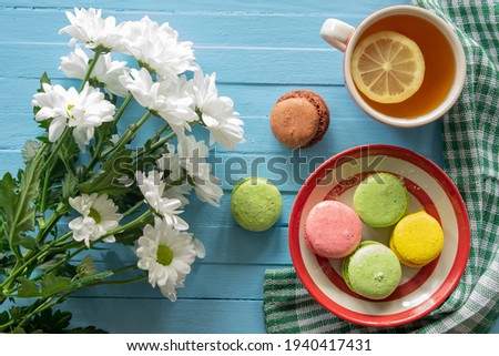 Composition good morning, cake and tea, flowers on a blue wooden background, top view