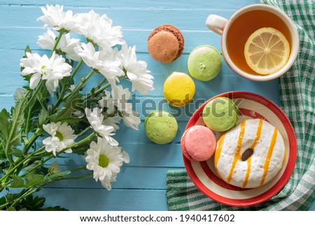 Composition good morning, cake and tea, flowers on a blue wooden background, top view