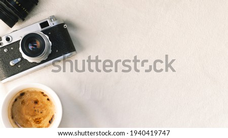 Retro camera and coffee lie on a soft blanket. Flatley background with items for the photographer.