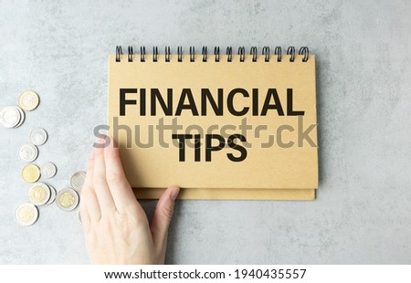 Business concept - workspace office desk and notebook writing FINANCIAL TIPS
