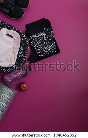 Stamped fashion sport clothes and accessories for woman with a wide copy space over pink background.