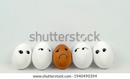 black egg among white eggs, racism and minority rejection concept Royalty-Free Stock Photo #1940490394