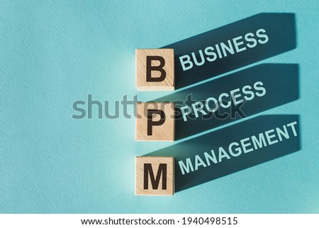 Wooden cubes building word BPM (abbreviation of Business process managemen) on light blue background. Royalty-Free Stock Photo #1940498515