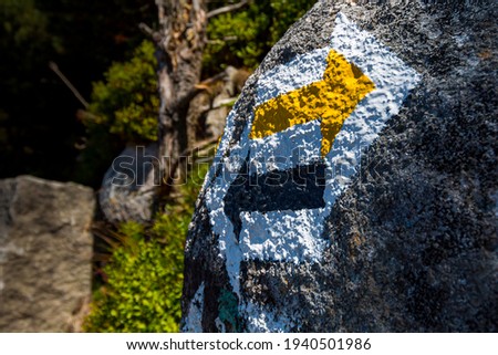 Marking on the mountain trail, arrows on the rock.