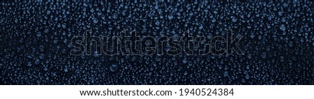Dark blue wide background of waterproof cloth with water drops Royalty-Free Stock Photo #1940524384