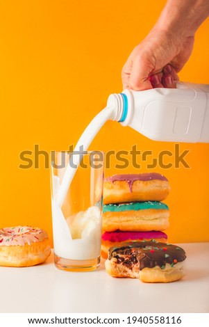 Sweet donuts with man hand pouring milk