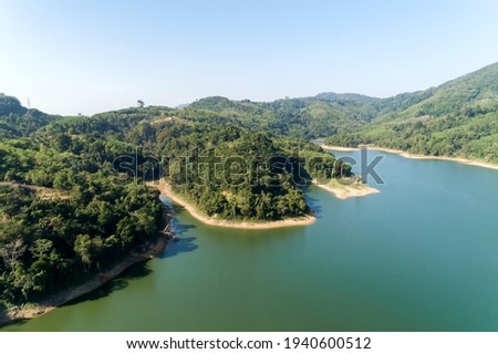 Aerial Drone shot bird eye view mountain lake with rainforest lake surrounded by mountains and reflection in the water.