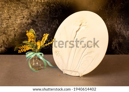 Stylish living room interior with botanical bas-relief spring flowers daffodils for wall art and flowers mimosa in vase. 3D Flower plaster decor. Modern and luxury interior of room