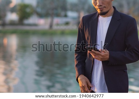 Businessman holding smartphone outdoor city park urban soft focus