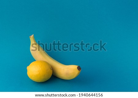 yellow fruit lemon and banana on a blue background with a copy of the space.
