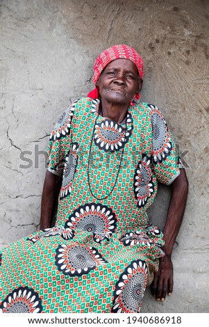 old african woman sitting next to the wall in a village in Botswana