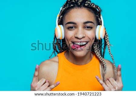 Beautiful girl with pigtails making party on a blue colored background
